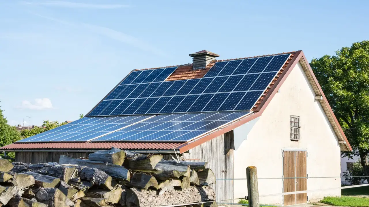 Panele słoneczne na dachu stodoły, gotowe do sprzedaży nadwyżek energii po atrakcyjnym **feed in tariff**.