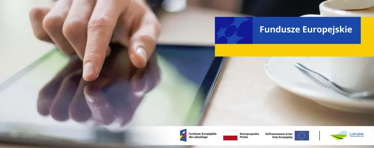 Dłoń dotyka ekranu tabletu, szukając informacji o pożyczki unijne. Na ekranie widnieje napis "Fundusze Europejskie".