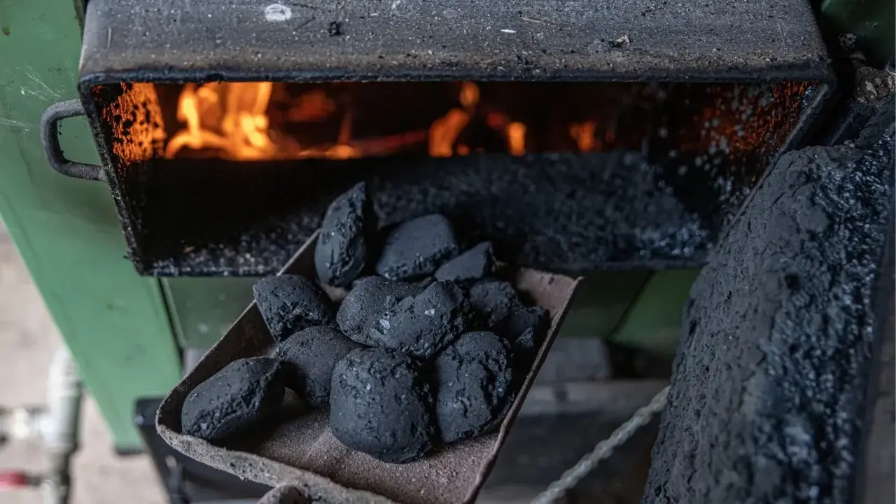 Łopata z węglem brunatnym czeka na załadunek do pieca bezklasowego, gdzie wesoło płonie ogień.