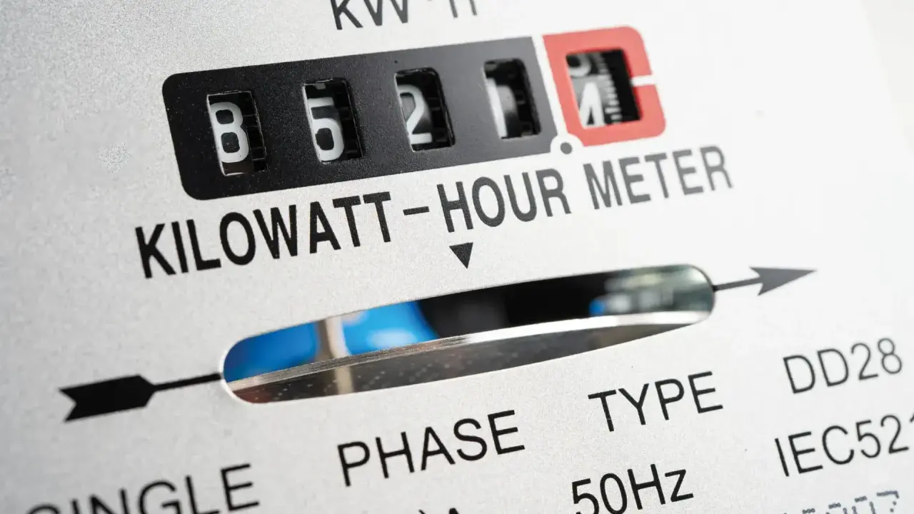 Zbliżenie licznika energii elektrycznej. Widoczne cyfry 85211, oznaczenie KILOWATT-HOUR METER. Wartość ta może wpływać na opłatę mocową.