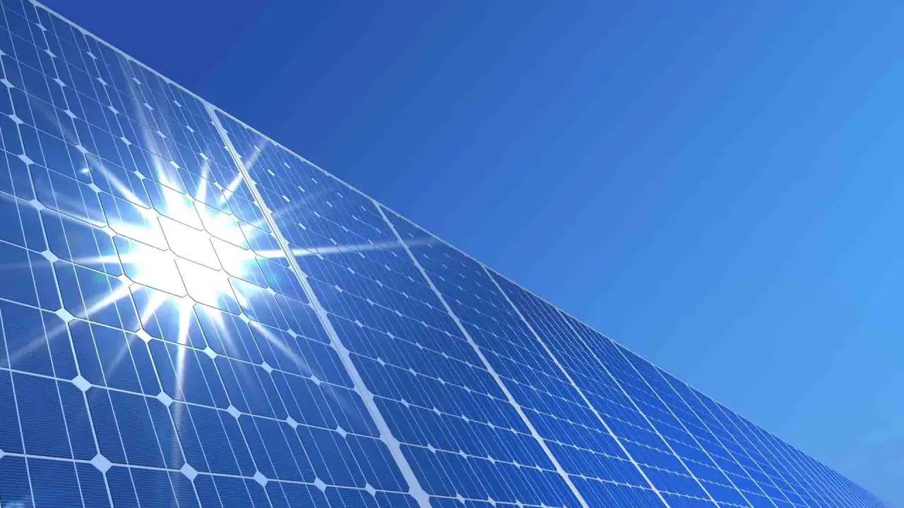 Błyszczące panele słoneczne pod błękitnym niebem. Słońce odbija się od nich, tworząc efektowny blask. To przyszłość energii, a ncbr co to? To Narodowe Centrum Badań i Rozwoju, które wspiera innowacje.