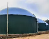 Zielone, cylindryczne zbiorniki z kopułami to biogazownia, gdzie powstaje energia z biomasy.