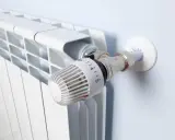 Biały grzejnik z termostatem. Zastanawiasz się, jakie ogrzewanie do mieszkania 70m2 wybrać? Ten element to klucz do komfortu.