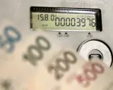 Liczniki energii i banknoty symbolizują koszty, w tym opłatę kogeneracyjną.