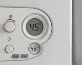 Panel sterowania pieca gazowego Vaillant z wyświetlaczem 45°C. Pokrętło regulacji temperatury ustawione na 1. Ekonomiczne ustawienie pieca gazowego Vaillant.