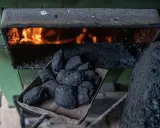 Łopata z węglem brunatnym czeka na załadunek do pieca bezklasowego, gdzie wesoło płonie ogień.