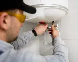 Instalator montuje zawór przy bojlerze. Szukasz odpowiedzi na pytanie: jaki piec gazowy do mieszkania 50m2?