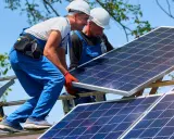 Dwóch monterów instaluje panele fotowoltaiczne. Zastanawiasz się, ile to kw? 10 kwp to moc szczytowa instalacji.
