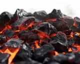 Żarzące się węgle, iskry unoszą się w powietrzu. Pytanie "do kiedy można palić węglem" nabiera znaczenia w obliczu takich obrazów.