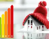 Model domu w czapce symbolizuje efektywną instalację grzewczą w domu. Obok wykres efektywności energetycznej.