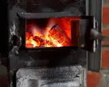 Żarzący się węgiel w starym piecu. Czas pomyśleć, do kiedy trzeba wymienić piec, zanim będzie za późno.