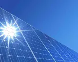 Błyszczące panele słoneczne pod błękitnym niebem. Słońce odbija się od nich, tworząc efektowny blask. To przyszłość energii, a ncbr co to? To Narodowe Centrum Badań i Rozwoju, które wspiera innowacje.