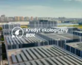 Nowoczesne budynki z panelami słonecznymi. Napis: Kredyt ekologiczny BGK.