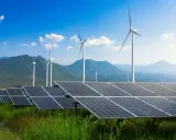 Panele słoneczne i wiatraki na tle gór i błękitnego nieba. To przyszłość, którą wspiera program Energia Plus.