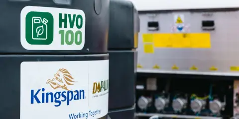 Zbiornik z ekologicznym paliwem HVO 100, obok logo Kingspan. Nowoczesne rozwiązanie dla transportu.