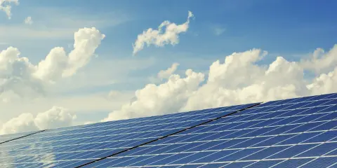 Panele słoneczne pod błękitnym niebem z chmurami. Czy to instalacja o mocy MWp?