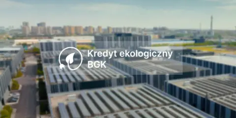 Nowoczesne budynki z panelami słonecznymi. Napis: Kredyt ekologiczny BGK.
