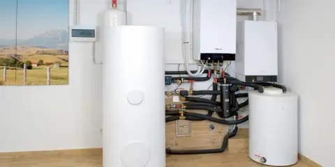Nowoczesny piec gazowy dwufunkcyjny i zasobnik wody. Instalacja grzewcza z widocznym czujnikiem ciśnienia.