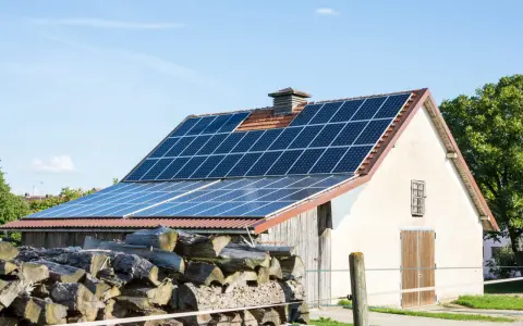 Panele słoneczne na dachu stodoły, gotowe do sprzedaży nadwyżek energii po atrakcyjnym **feed in tariff**.