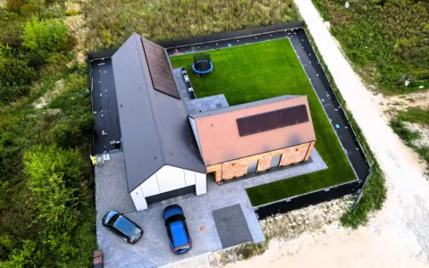 Nowy dom pod klucz co to znaczy? Gotowy do zamieszkania, z panelami słonecznymi, zadbanym ogrodem i dwoma samochodami na podjeździe.
