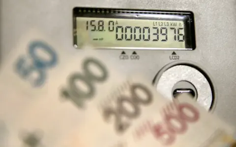 Liczniki energii i banknoty symbolizują koszty, w tym opłatę kogeneracyjną.