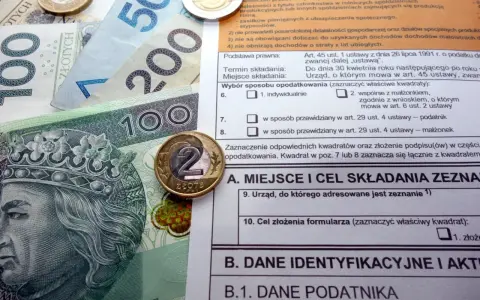 Polskie banknoty i monety na tle formularza podatkowego, ilustrujące ulga termomodernizacyjna – przykład rozliczenia.