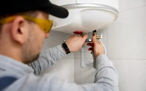 Instalator montuje zawór przy bojlerze. Szukasz odpowiedzi na pytanie: jaki piec gazowy do mieszkania 50m2?