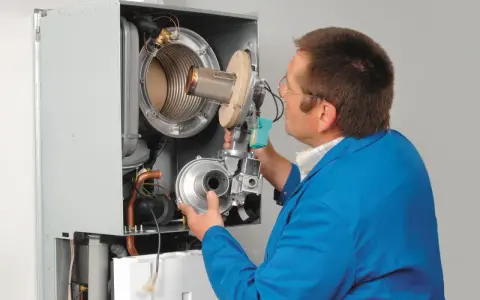 Serwisant sprawdza ciśnienie wody w kotle Viessmann Vitodens 050.