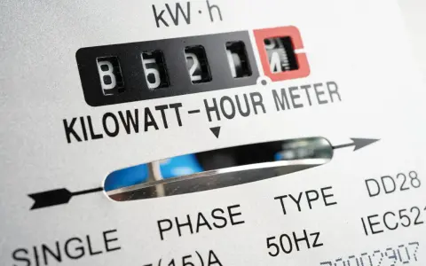 Zbliżenie licznika energii elektrycznej. Widoczne cyfry 85211, oznaczenie KILOWATT-HOUR METER. Wartość ta może wpływać na opłatę mocową.