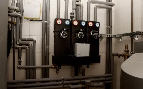 System grzewczy z pompami i manometrami. Zastanawiasz się, jakie rury do pieca węglowego wybrać? Tutaj widzisz izolowane rury i elementy instalacji.