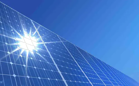 Błyszczące panele słoneczne pod błękitnym niebem. Słońce odbija się od nich, tworząc efektowny blask. To przyszłość energii, a ncbr co to? To Narodowe Centrum Badań i Rozwoju, które wspiera innowacje.