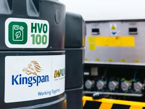 Zbiornik z ekologicznym paliwem HVO 100, obok logo Kingspan. Nowoczesne rozwiązanie dla transportu.