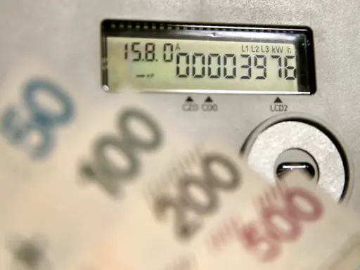 Liczniki energii i banknoty symbolizują koszty, w tym opłatę kogeneracyjną.
