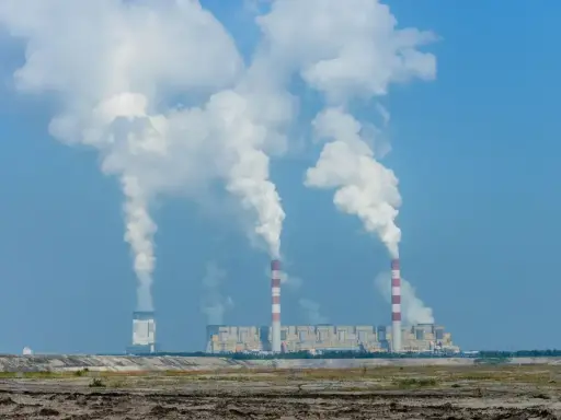 Ogromne ilości pary unoszą się z kominów elektrowni Bełchatów, sugerując, ile węgla spala elektrownia Bełchatów.