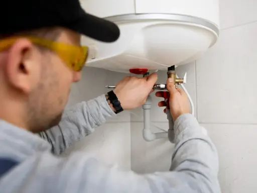 Instalator montuje zawór przy bojlerze. Szukasz odpowiedzi na pytanie: jaki piec gazowy do mieszkania 50m2?