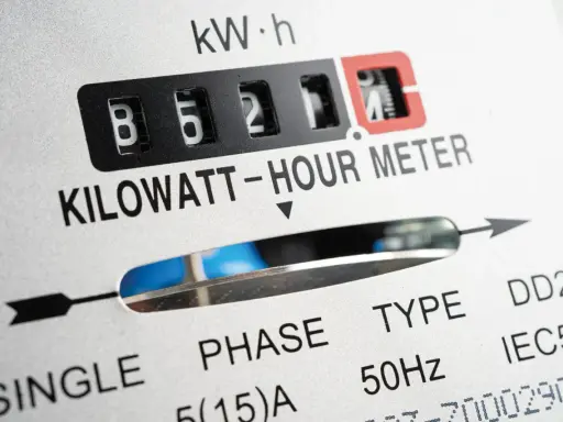 Zbliżenie licznika energii elektrycznej. Widoczne cyfry 85211, oznaczenie KILOWATT-HOUR METER. Wartość ta może wpływać na opłatę mocową.