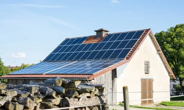 Panele słoneczne na dachu stodoły, gotowe do sprzedaży nadwyżek energii po atrakcyjnym **feed in tariff**.