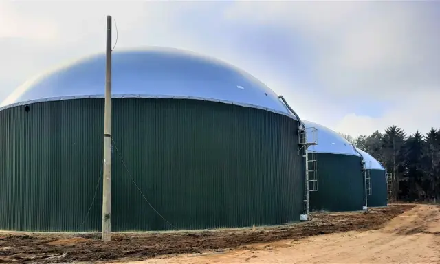 Zielone, cylindryczne zbiorniki z kopułami to biogazownia, gdzie powstaje energia z biomasy.