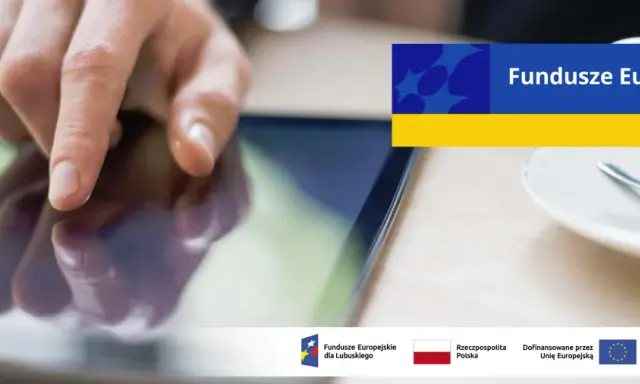 Dłoń dotyka ekranu tabletu, szukając informacji o pożyczki unijne. Na ekranie widnieje napis "Fundusze Europejskie".