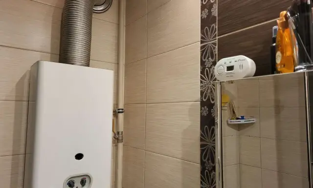 Czujnik czadu zamontowany na półce nad lustrem, blisko gazowego podgrzewacza wody.