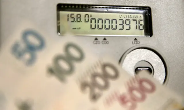 Liczniki energii i banknoty symbolizują koszty, w tym opłatę kogeneracyjną.