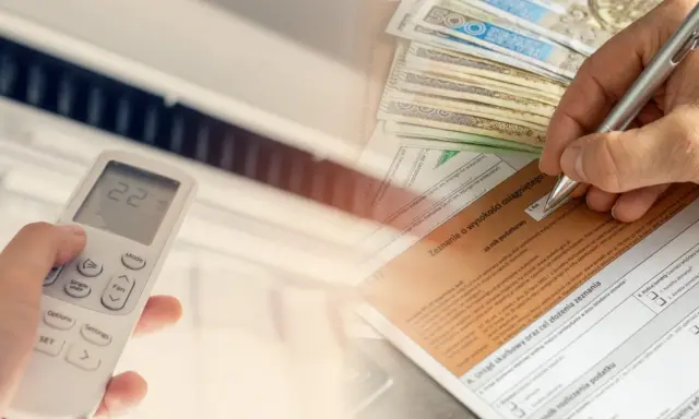Ręka trzymająca pilot do klimatyzacji, obok stos banknotów i formularz podatkowy. Czy klimatyzację można odliczyć od podatku?