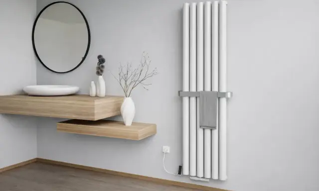Nowoczesna łazienka z białym grzejnikiem, który może mieć wady grzejników aluminiowych. Obok umywalka i lustro.