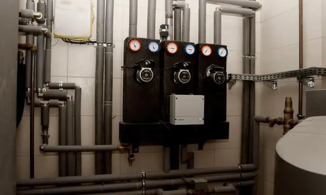 System grzewczy z pompami i manometrami. Zastanawiasz się, jakie rury do pieca węglowego wybrać? Tutaj widzisz izolowane rury i elementy instalacji.