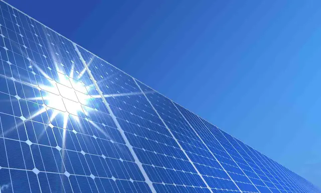 Błyszczące panele słoneczne pod błękitnym niebem. Słońce odbija się od nich, tworząc efektowny blask. To przyszłość energii, a ncbr co to? To Narodowe Centrum Badań i Rozwoju, które wspiera innowacje.