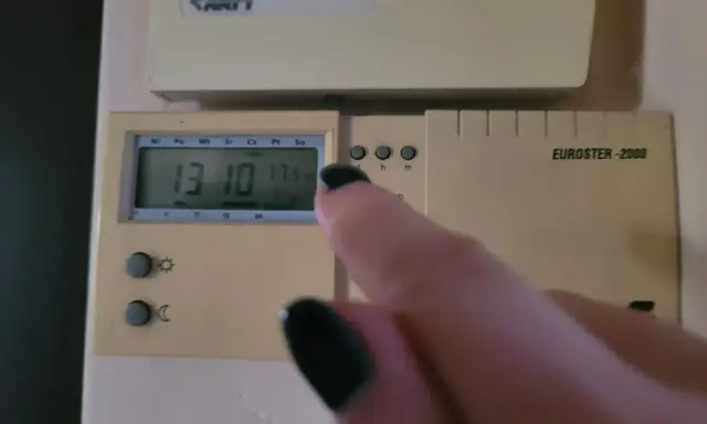 Dłoń z czarnym lakierem na paznokciach dotyka termostatu, sterowanie piecem gazowym. Na wyświetlaczu 13:10 i 17.5°C.