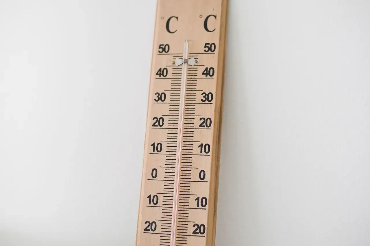 Drewniany termometr wskazuje temperaturę bliską 20°C, co oznacza optymalną temperaturę w domu dla komfortu i zdrowia.