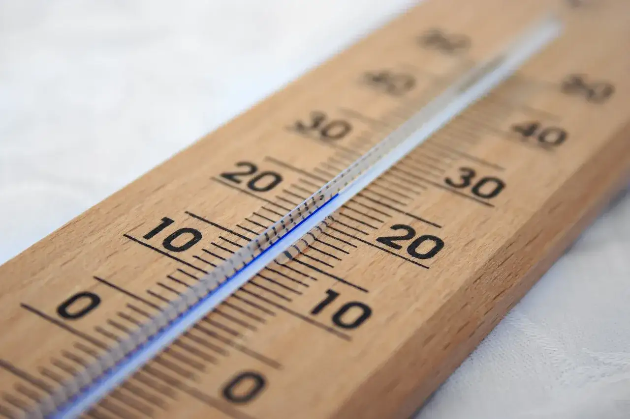 Drewniany termometr wskazuje temperaturę około 20 stopni Celsjusza, co jest optymalną temperaturą w domu.